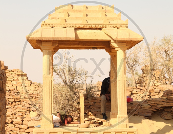 A man in a mandap at ruins in a desert