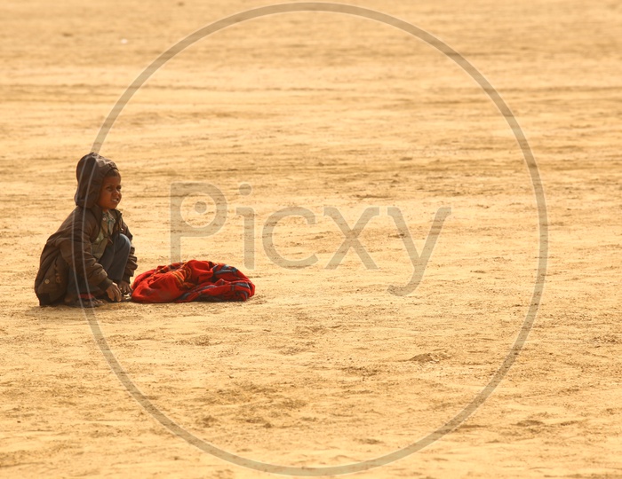 A child with a bag in the desert