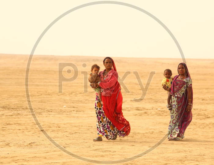 Indian Women with Kids walking in desert