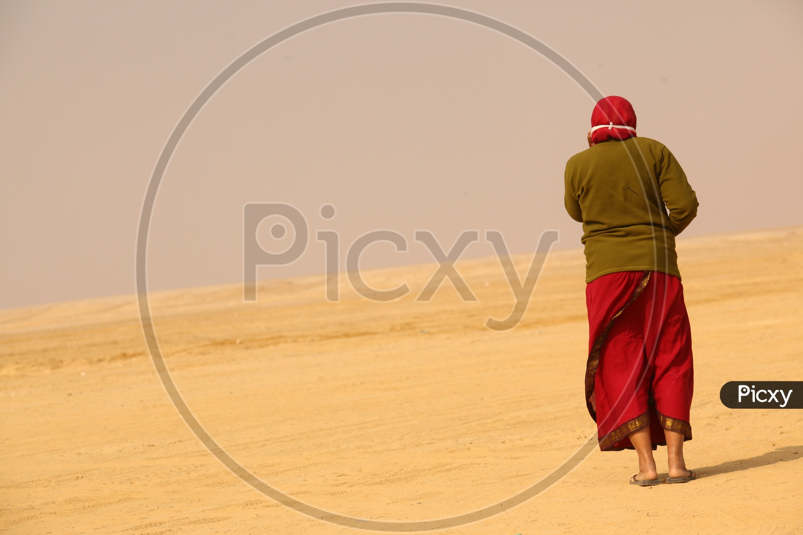 Indian woman walking in desert