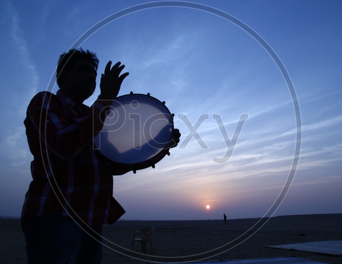 Silhouette of a person playing drums