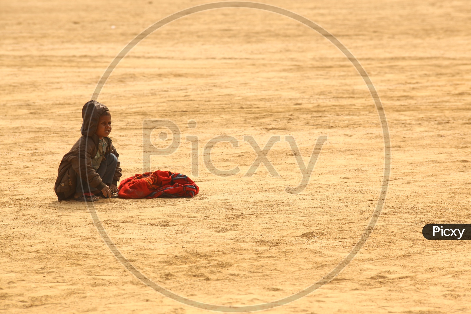 A child with a bag in the desert