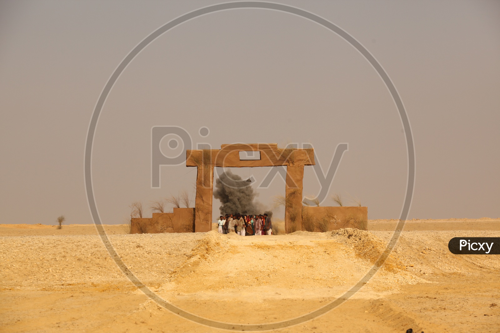 people standing at the arch like entrance in a desert
