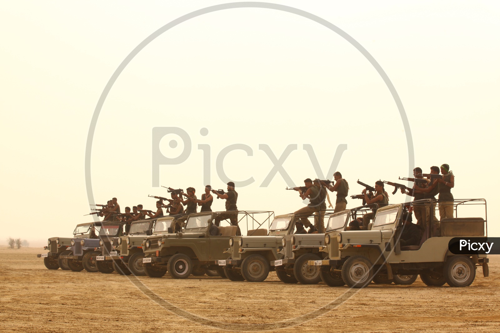 group of people with guns on the vehicles in a desert,  bandits