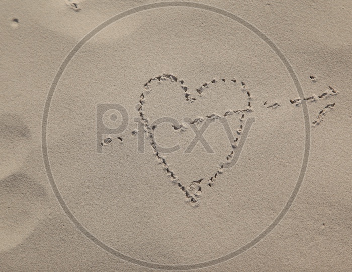 Symbol of love (heart and arrow) on the sand