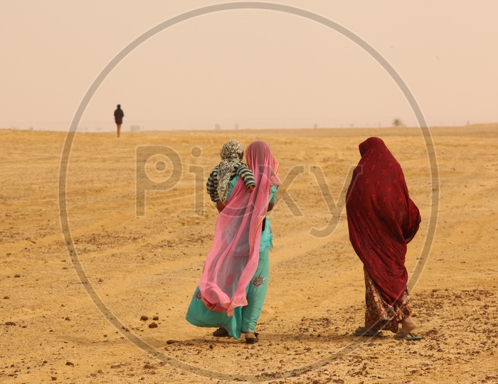 Indian woman's walking in a desert