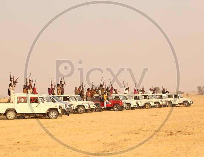 People with guns on vehicles in a desert