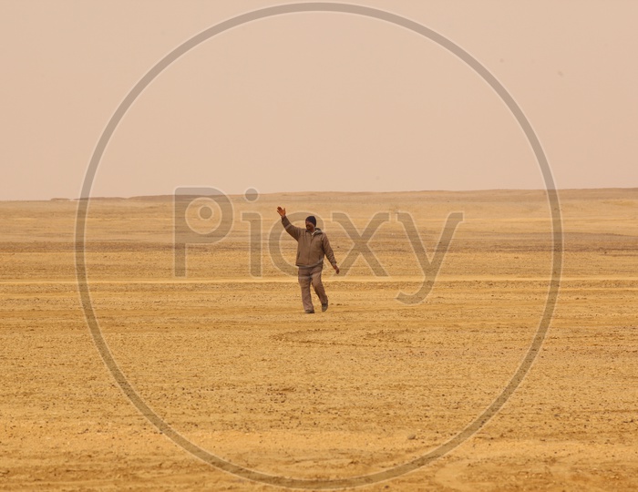 Indian Man walking in a desert