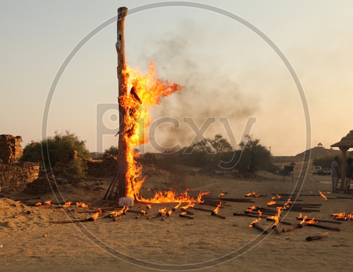 A man is tied to a pole and burnt