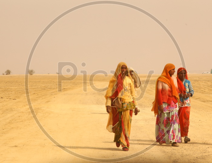 Indian old woman's walking in a desert