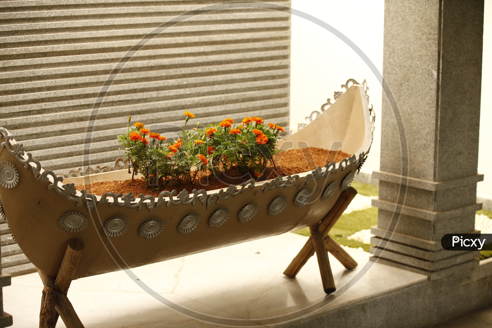 A boat shaped pot with marigold plants