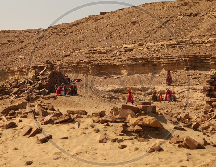 Women sitting alongside the old ruins in a desert