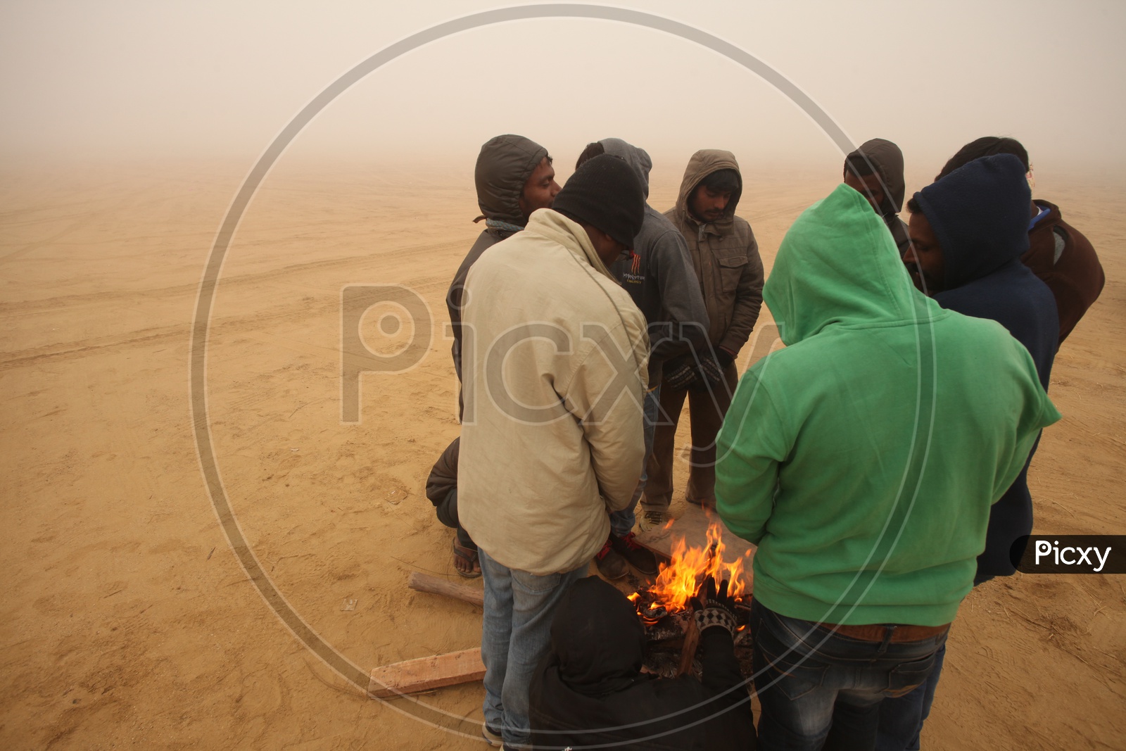 People in a desert with camp Fire