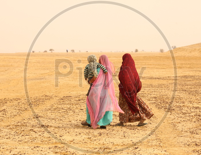 Indian woman's walking in a desert