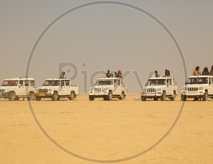 vehicles with people moving in desert