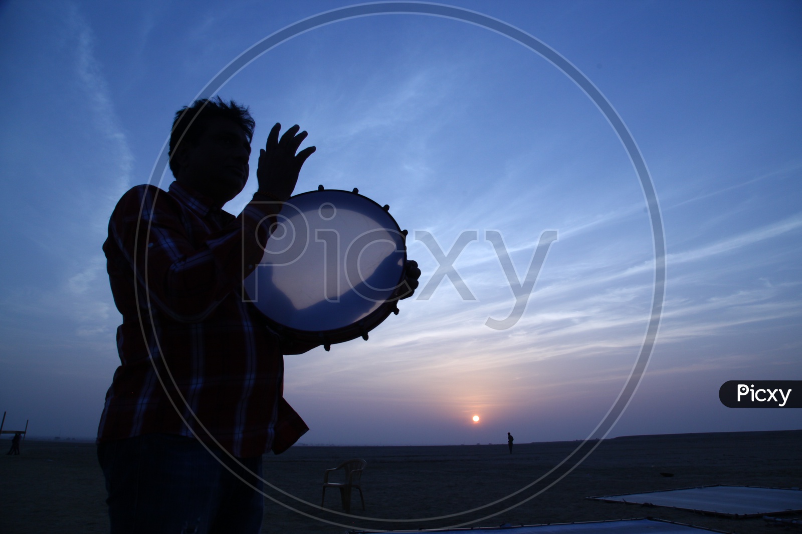 Silhouette of a person playing drums