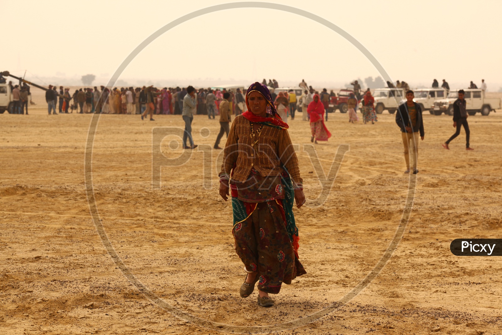 Indian old woman walking in desert