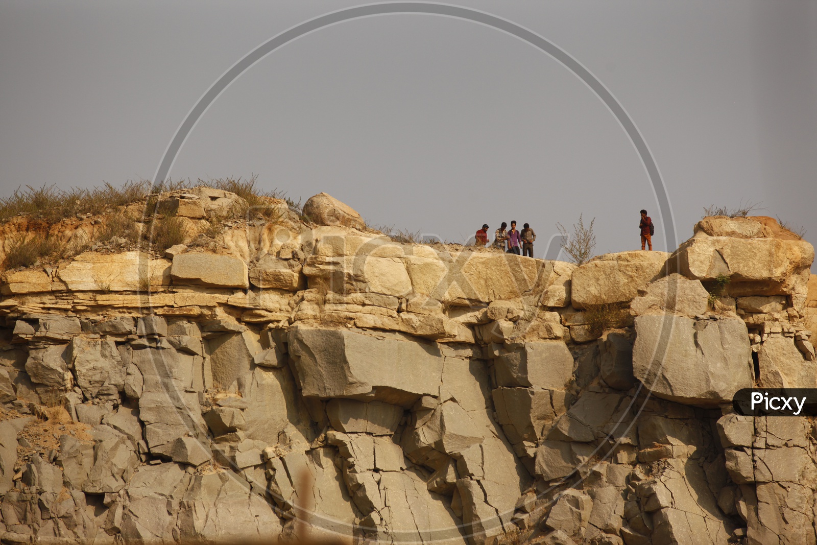Men standing on a rock hill