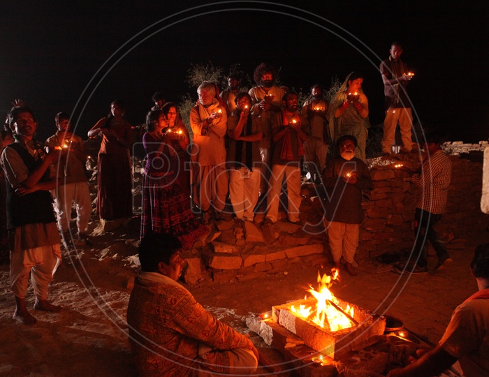People holding oil lamps during the night
