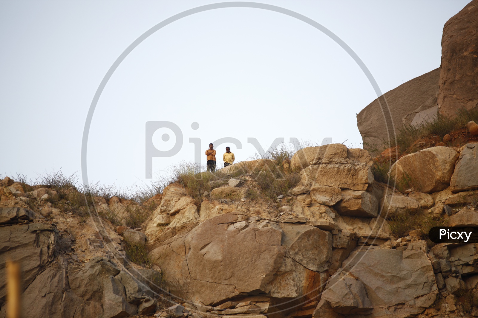 Two men standing on the rocky hill
