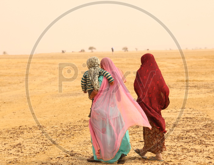 Indian old woman's walking in a desert