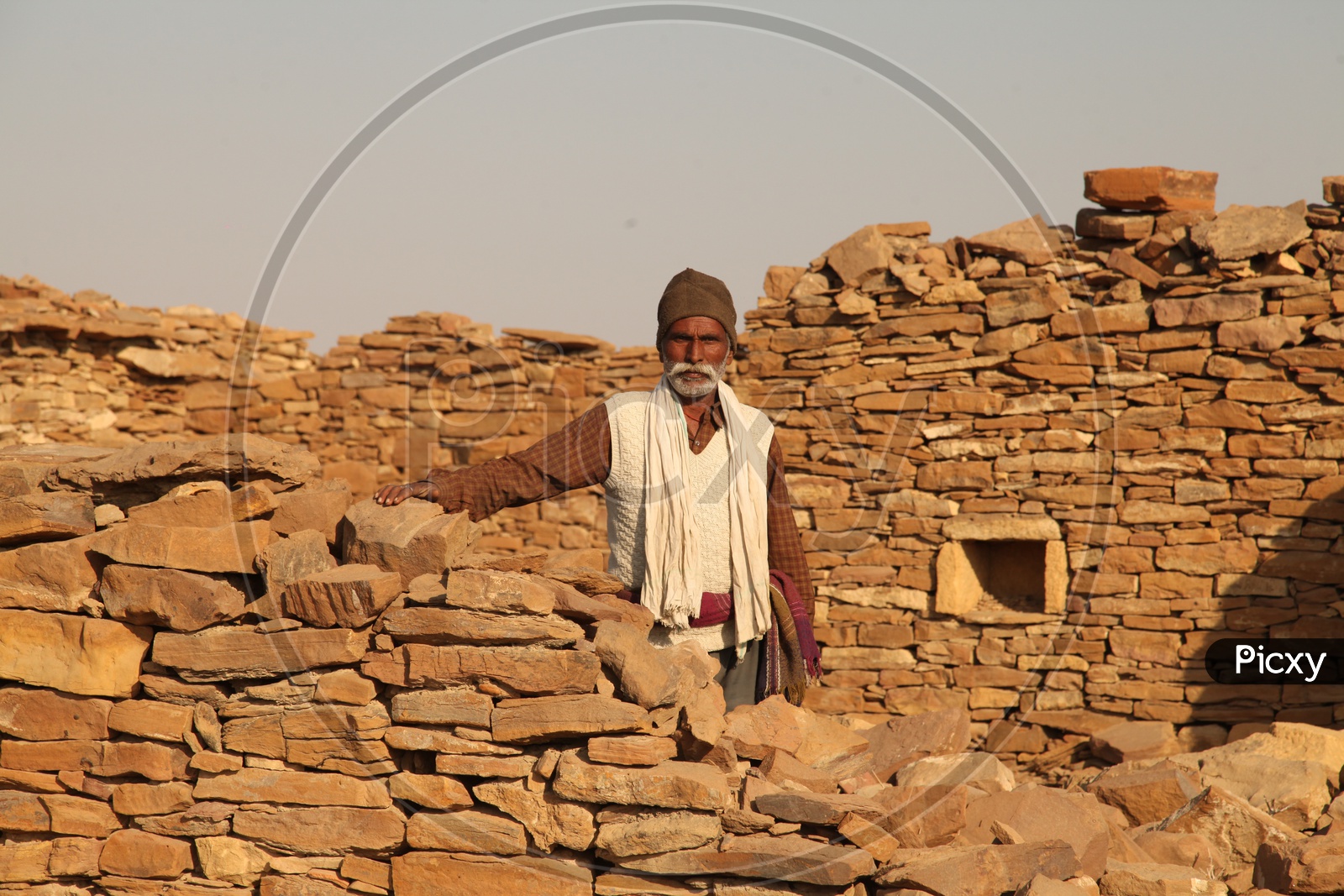 Indian old man alongside the old ruins