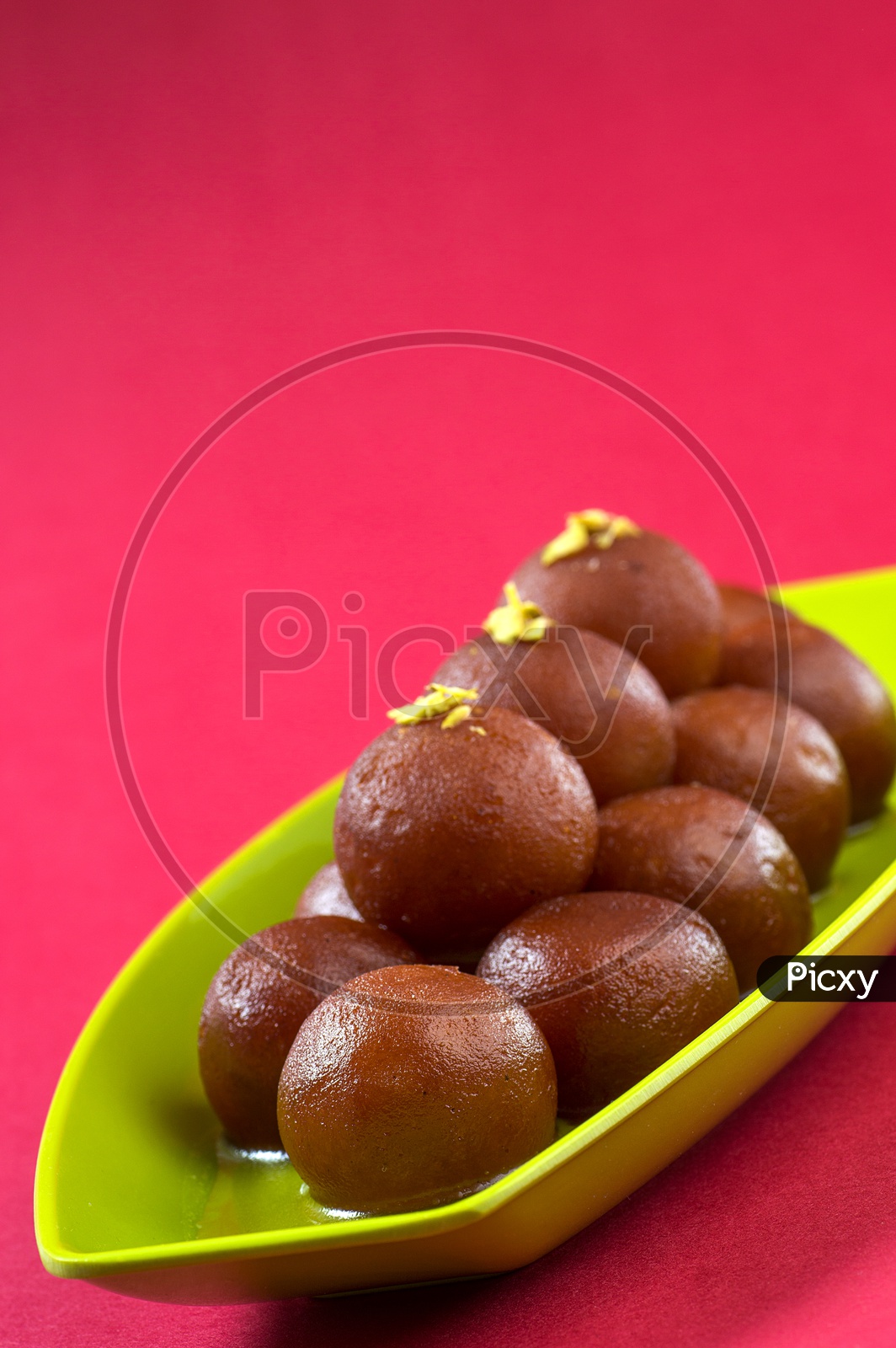 Indian Dessert or Sweet Dish Gulab Jamun topped with pistachio