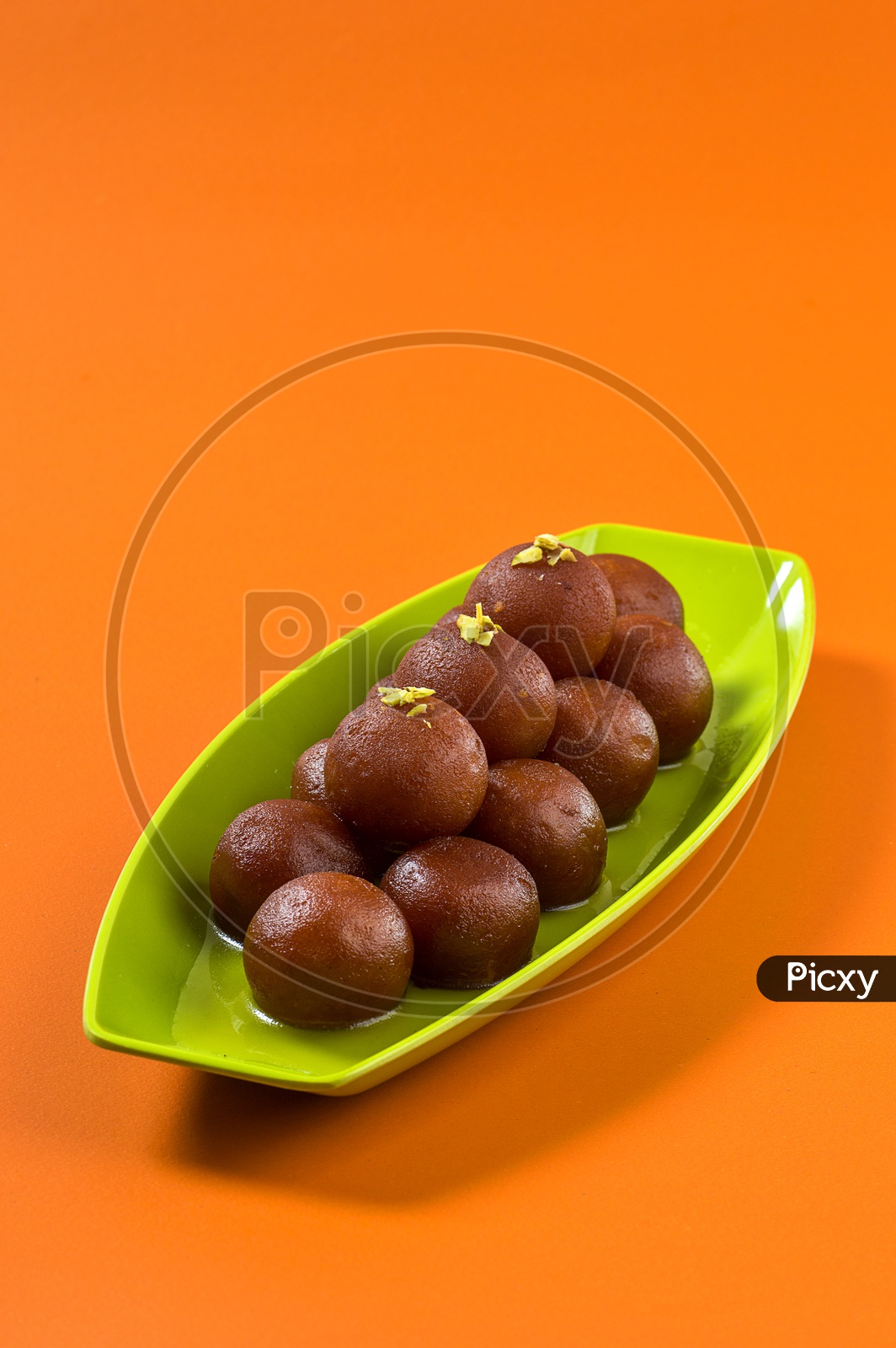 Indian Dessert or Sweet Dish Gulab Jamun topped with Pistachio