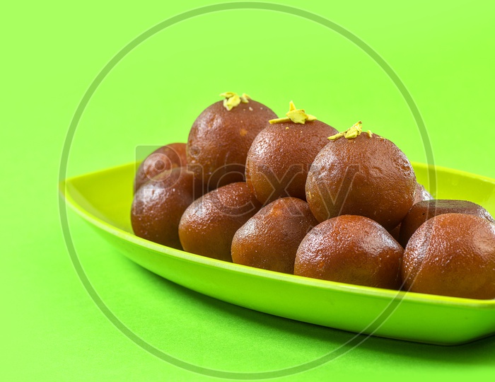 Indian Dessert or Sweet Dish Gulab Jamun topped with Pistachio