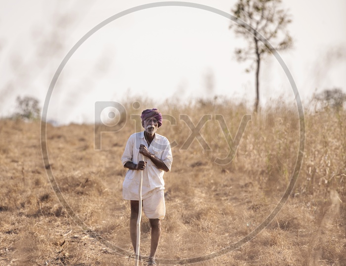 A Farmer Along His Dried Farm Land in Rural Village