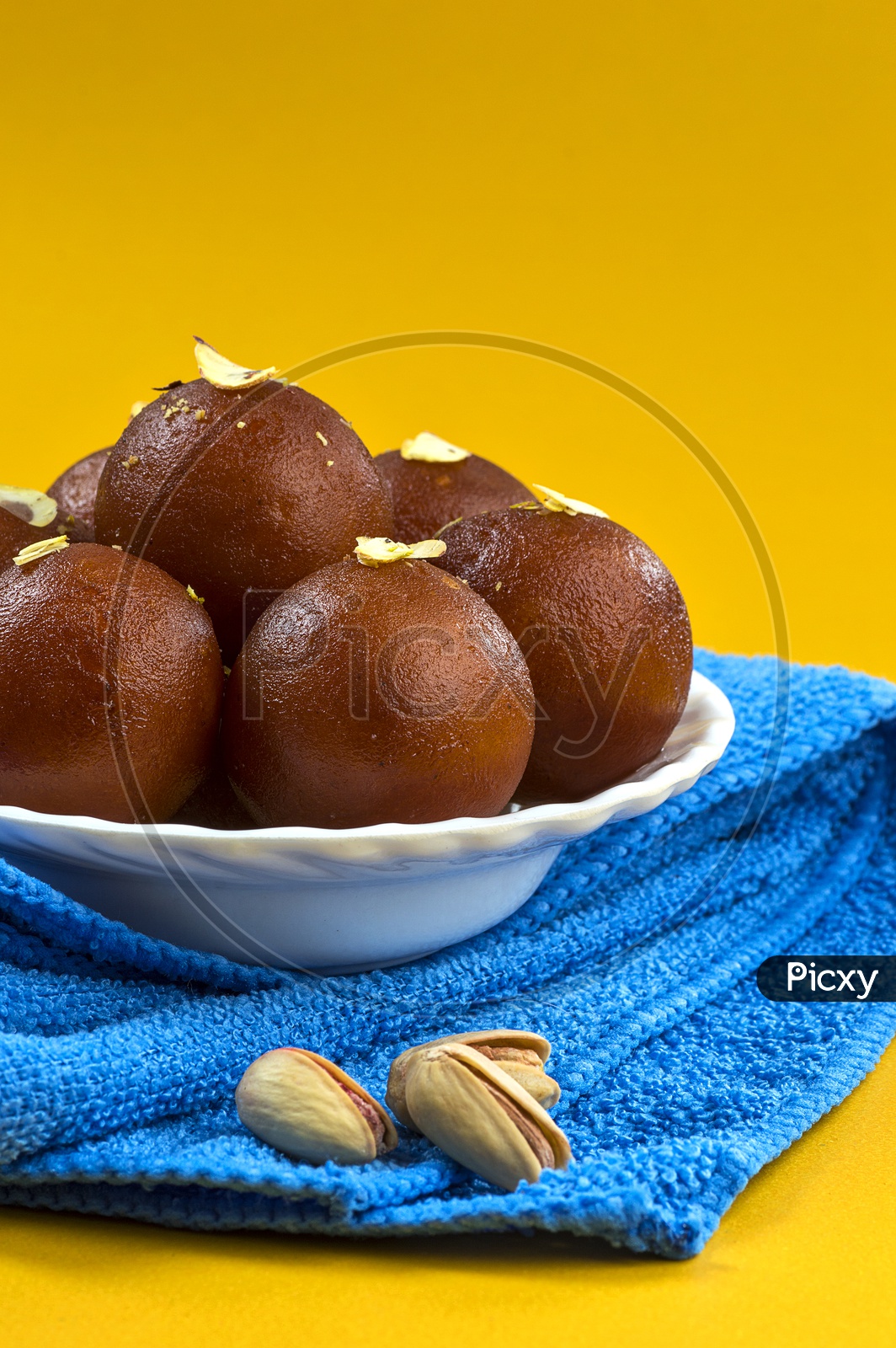 Indian Dessert or Sweet Dish Gulab Jamun topped with Pistachio in Plate with Napkin