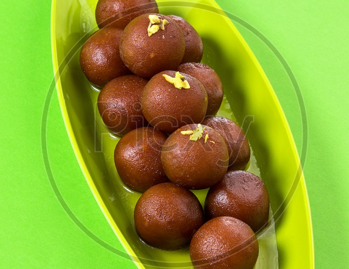 Indian Dessert or Sweet Dish Gulab Jamun topped with pistachio