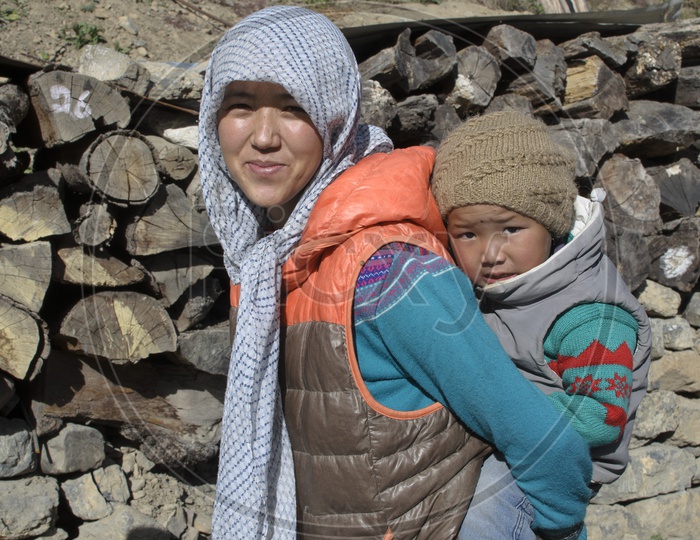 Portrait Of a Mother Carrying Her Child In Back as a Backpack in Ladakh