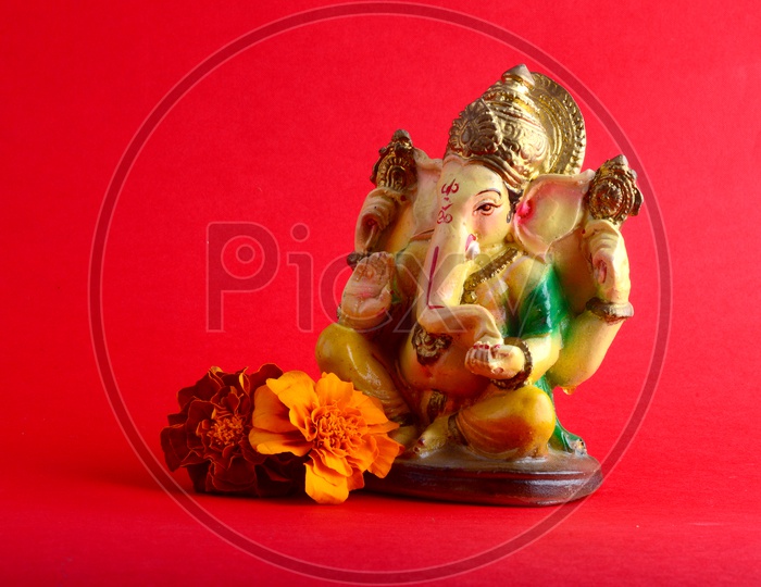 Hindu God Ganesha or Ganapathi. Lord Ganesha Idol on Red Background