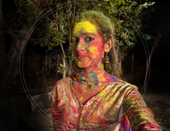 Young Indian Girl Taking Selfies with Colors on Face On Smart Phone