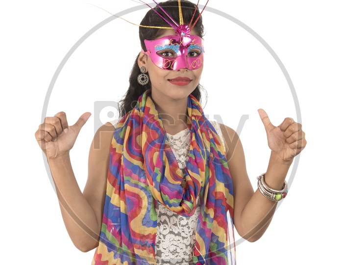 Young Indian Girl Wearing Carnival Mask With  Smiling Face  and Showing Thumps up