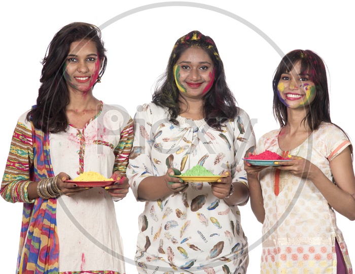 A Group Of Young Girls Holding Color Powder Plates and Celebrating Holi