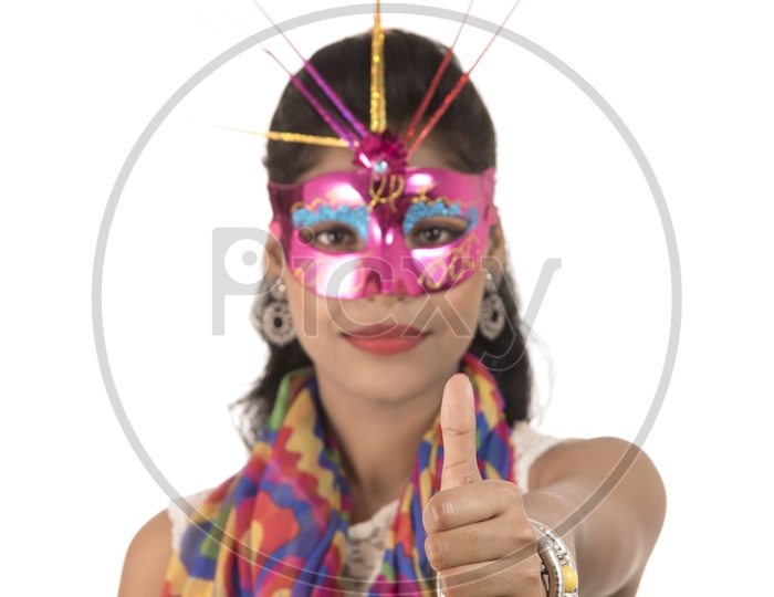 An Young Indian Girl Wearing Carnival Mask and Showing Thumps Up