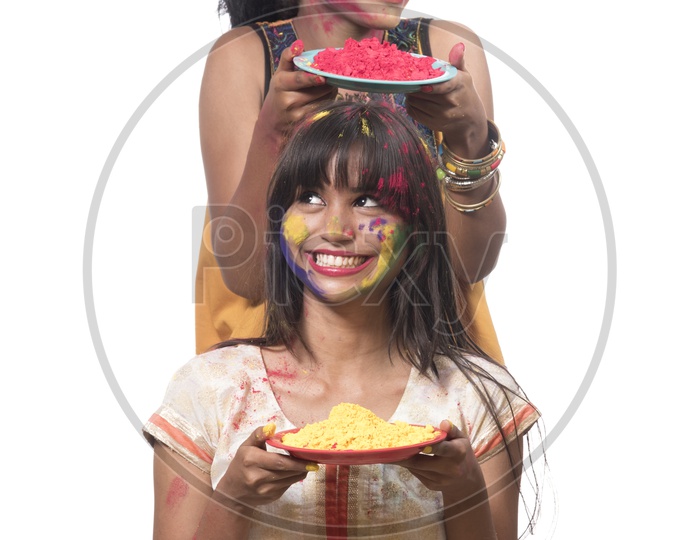 Young Indian Girls Holding Holi Color Powder Plates and Celebrating Holi