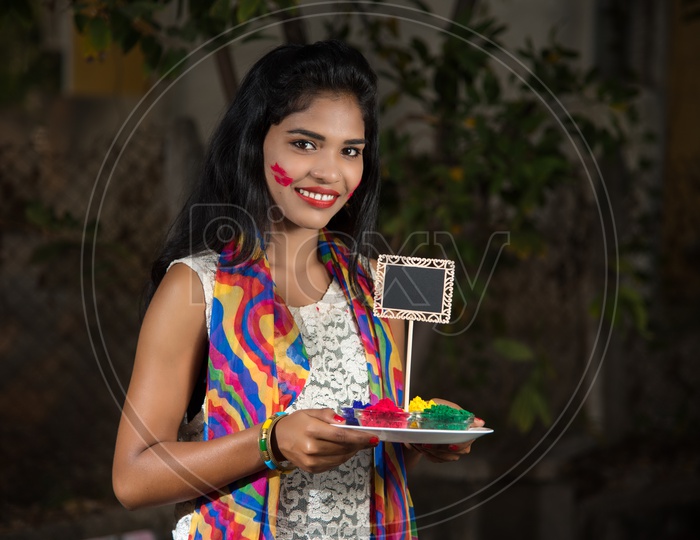 Young Indian Girl With Holi  Color Powder Plate In Hand With Smiling Face
