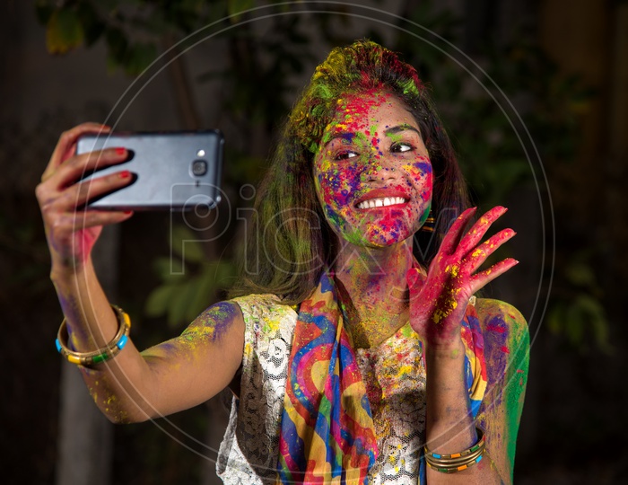 Indian  Young Girl Taking Selfie With Holi Colors On her with Smart Phone