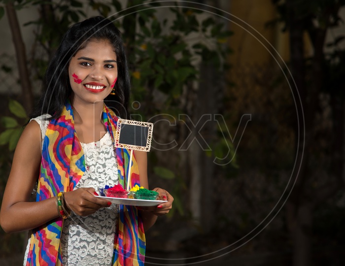 young Indian Girl With Color Powder Plate And Smile On Face