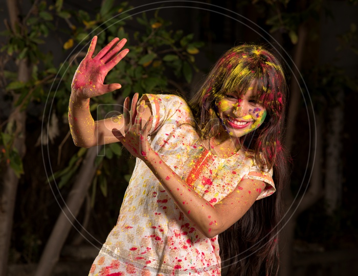 Young Indian Girl Happily Playing With Colors Celebrating Holi , Festival Of Colors