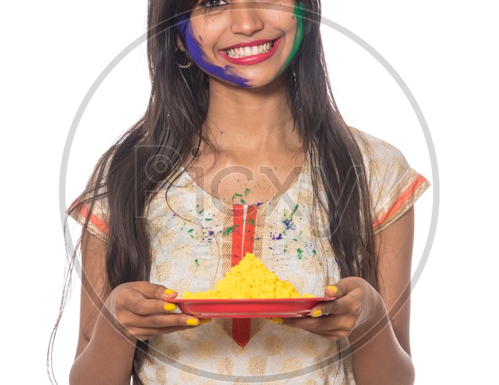Happy Young Indian Girl With Color Powder Plates Having Fun at Holi , Festival Of Colors