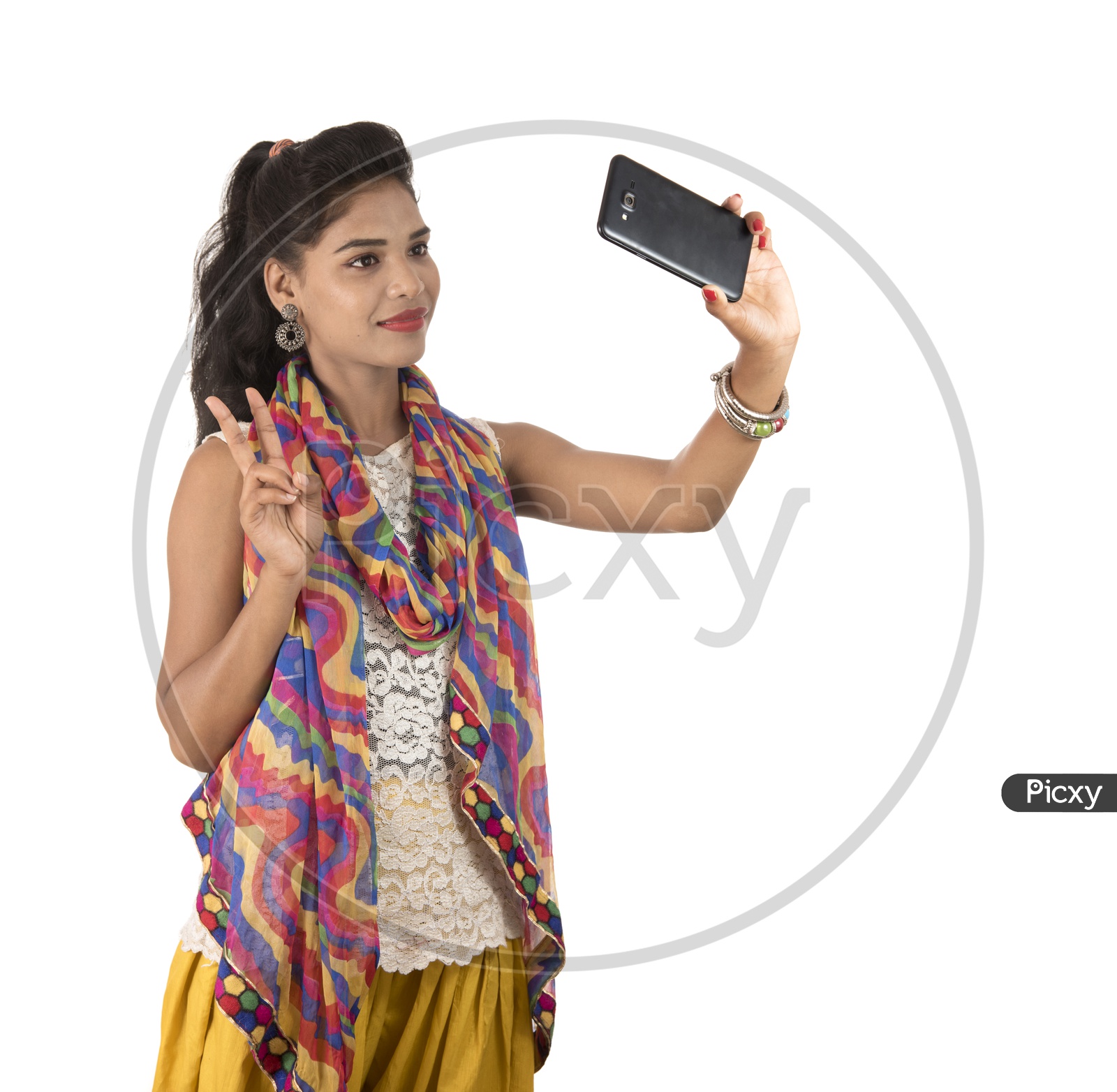 young Indian Girl Taking Selfie with Smart Phone with Smiling Face And Showing Victory Symbol