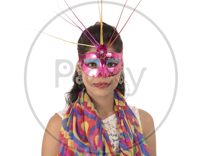 A Happy Young Indian Girl Wearing Carnival Mask over a White Background