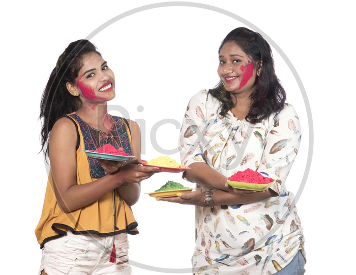 Young Indian Girls Holding Holi Color Plates and Celebrating Holi