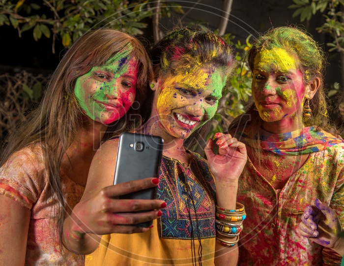Group Of Young Girls filled In Holi  Colors Taking Selfie With Smart Phone