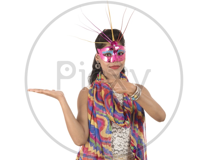 Young Indian Girl Wearing Carnival Mask With Smiling Face And Showing Space
