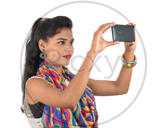 A Happy Young Indian Girl Taking Pictures On Mobile Or Smart Phone